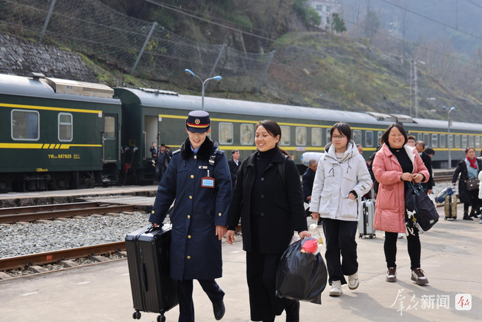 列车停靠间隙，黄瑶（左）主动帮旅客拎运行李，护送乡亲们安全出站。