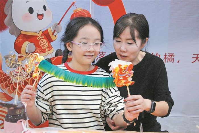     2月24日，在八师石河子市向阳街道“马跃新程·非遗贺岁”游园会上，家长和孩子一起做花灯。刘胜  摄
