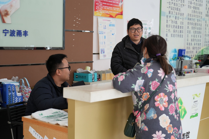 工作人员指导农户购买农资。