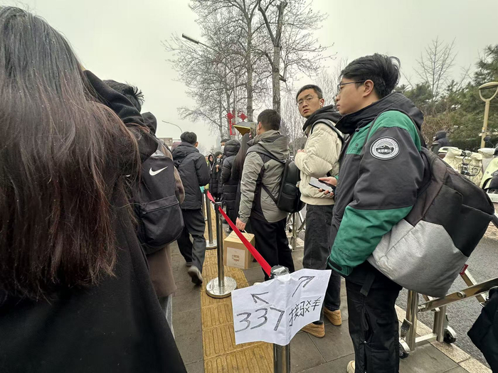 玉泉路口西公交站（向西方向），为引导不同线路乘客有序排队，站台设置了临时隔离栏杆并标明所排线路。千龙网记者 徐锟 摄
