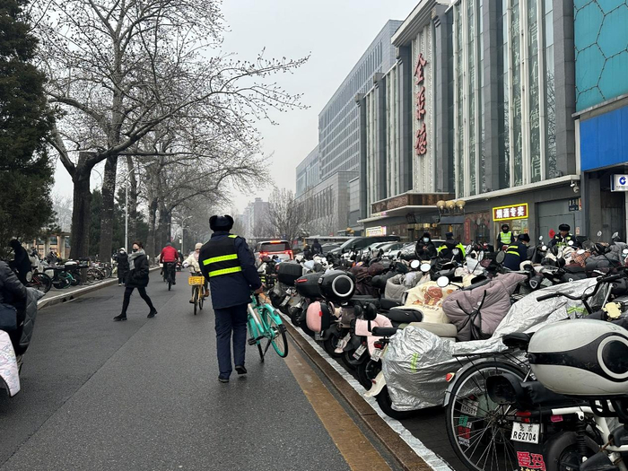 今晨7点，工作人员正在搬运共享单车，进行现场调度。千龙网记者 徐锟 摄