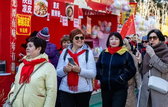 2026年2月17日，外国游客在北京龙潭湖公园逛春节文化庙会。