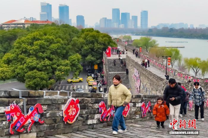 3月4日，江苏南京，市民登上有着600多年历史的明城墙欣赏风景。中新社记者 泱波 摄
