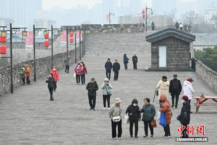 3月4日，江苏南京，市民登上有着600多年历史的明城墙欣赏风景。中新社记者 泱波 摄