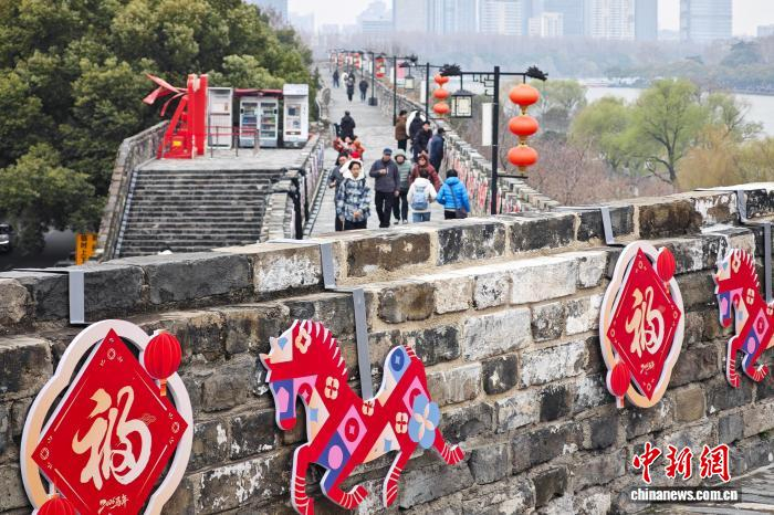 3月4日，江苏南京，市民登上有着600多年历史的明城墙欣赏风景。中新社记者 泱波 摄