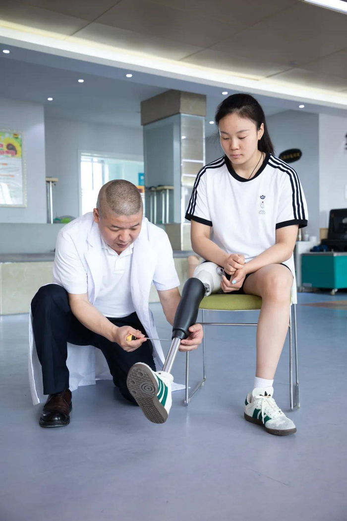 装配机构内,装配师正在为仿生腿用户调试仿生腿。图|受访者提供