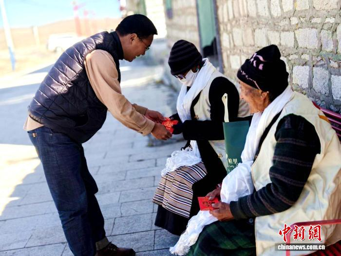  图为驻村工作队为老人送祝福。社区工作队 供图
