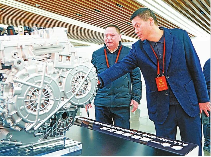 ▲2025年2月，殷其龙（右）在赛力斯超级工厂参加全国人大代表集中调研活动。