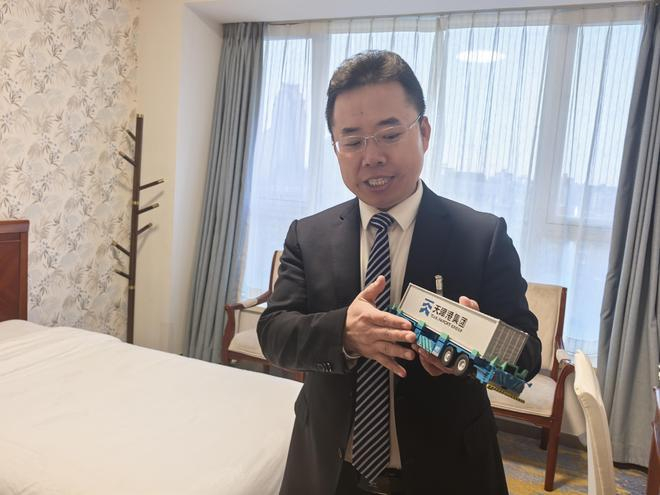 　　全国人大代表、天津港第一港埠有限公司拖头队副队长成卫东正在介绍智能运输机器人。新华社记者周圆 摄