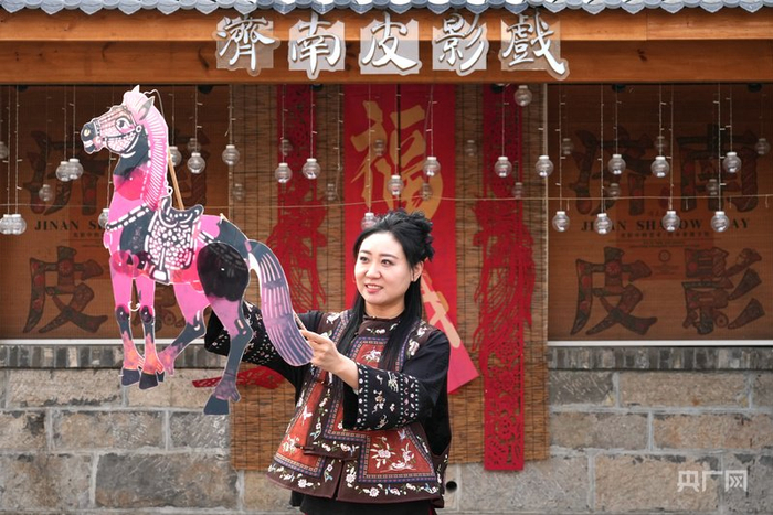 李娟和她制作的马年皮影（央广网记者  唐磊  摄）