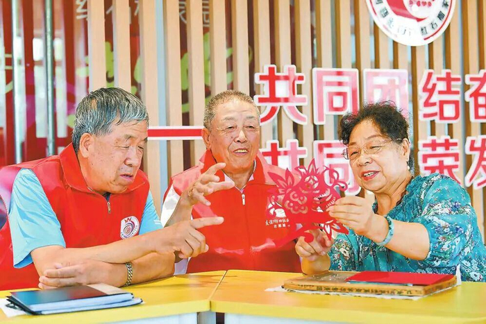 在包头市，红石榴宣讲团成员与社区居民一起剪纸。 孟和朝鲁 摄