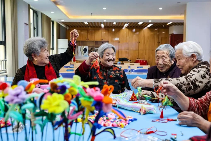 2025年12月19日，山东省乐陵市德乐怡嘉长者公寓的老人们在制作福袋包。新华社发 