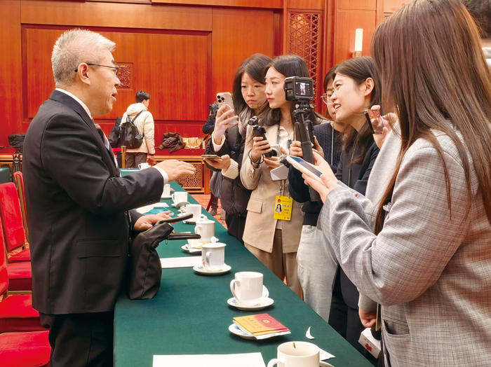 图为3月7日上午，十四届全国人大四次会议江苏代表团全体会议结束后，多位女记者采访全国人大代表、中国社会科学院学部委员张翼。