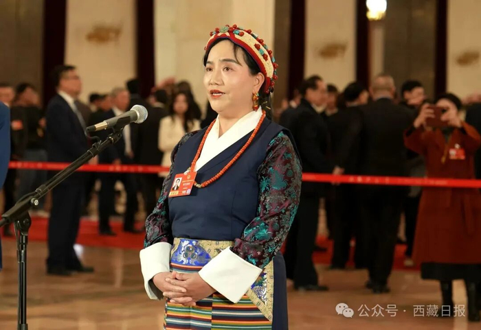 图为在全国政协十四届四次会议第二场“委员通道”，明吉措姆回答记者提问。记者 陶玥 摄