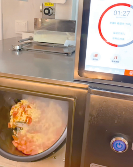 智能炒菜机器人正在制作西红柿炒鸡蛋