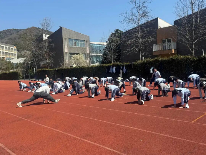 滨海新城实验学校的老师正带着学生热身。学校供图