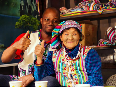 史蒂芬穿着独龙族传统服饰与独龙族纹面老人合影。供图