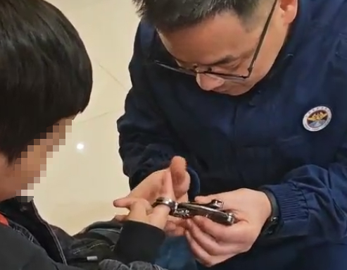 男孩手指卡在“蝴蝶刀”的环扣中。图源：南通消防
