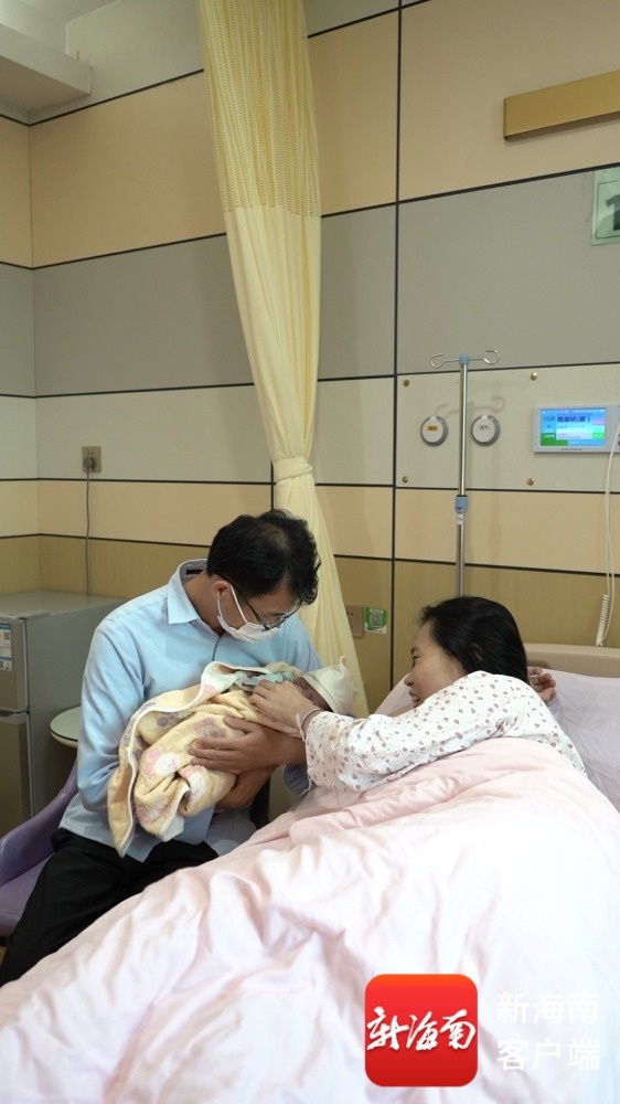 在海口市妇幼保健院，陈先生与爱人在照顾刚出生的宝宝。