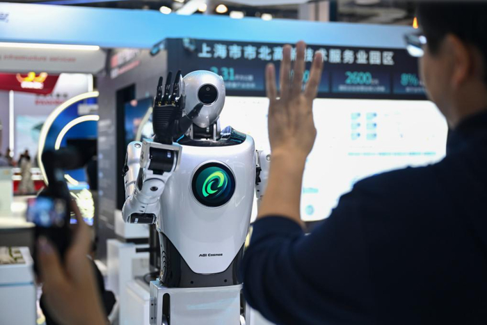 游客和智行鸿宇人形机器人互动。图片来源：新华社