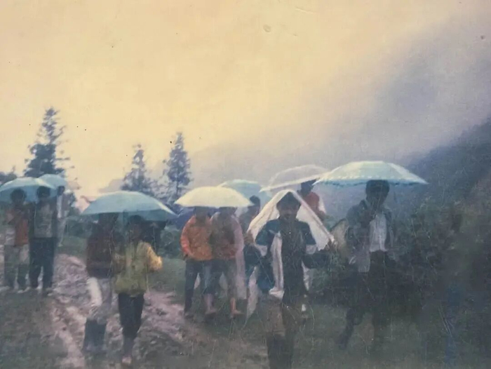 学生冒雨送别农加贵。图源：人民日报