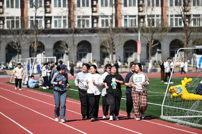 2025年3月21日，在中国农业大学东校区，减脂课教师张晖（左一）指导学生慢跑。新华社记者 陈钟昊 摄
