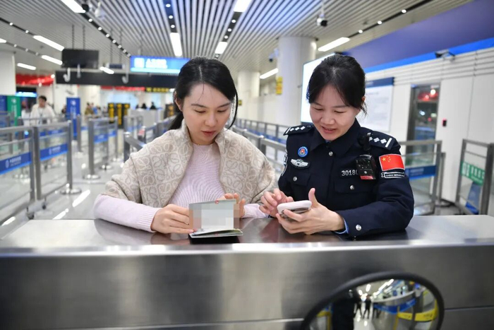 深圳边检总站莲塘边检站民警协助旅客网上填报外国人入境卡。（赵伟峻 摄）