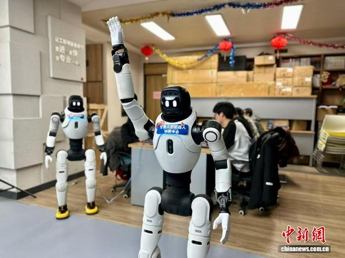 3月13日，甘肃兰州市城关区，机器人训练师训练人形机器人做出指定动作。中新社记者 闫姣 摄