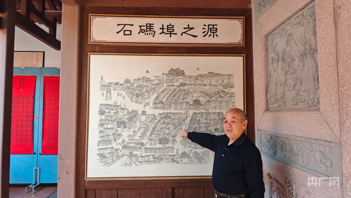 林靖华老人在他的画作《石码埠之源》前讲述龙海的历史故事（央广网记者  张子剑  摄）