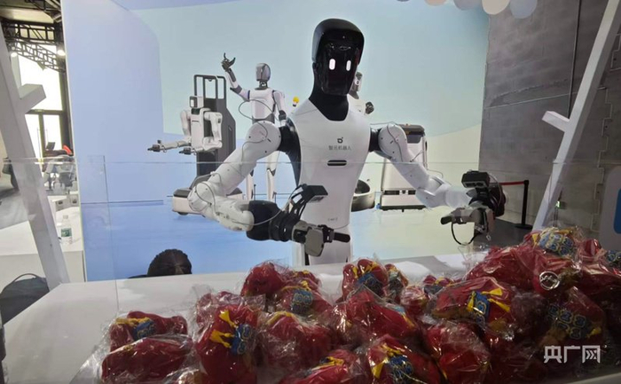 机器人正在抓取礼物递给观众（央广网记者 林馥榆 摄）