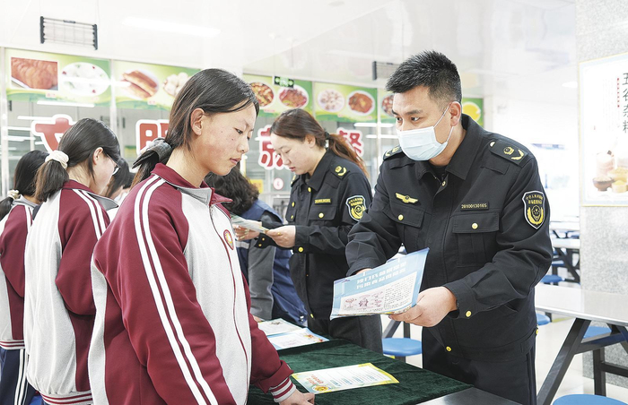 工作人员为学生讲解食品安全知识。 通讯员 翟娜娜 摄