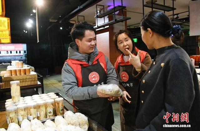 图为超市聋哑员工用手语为顾客介绍商品。 梅镱泷 摄 