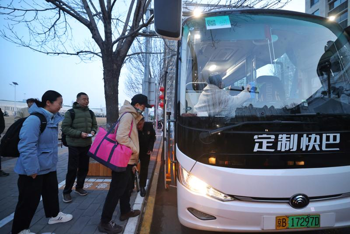 3月16日清晨，草桥地铁站A口外，乘坐京雄定制快巴的乘客正排队上车。新京报记者 王贵彬 摄