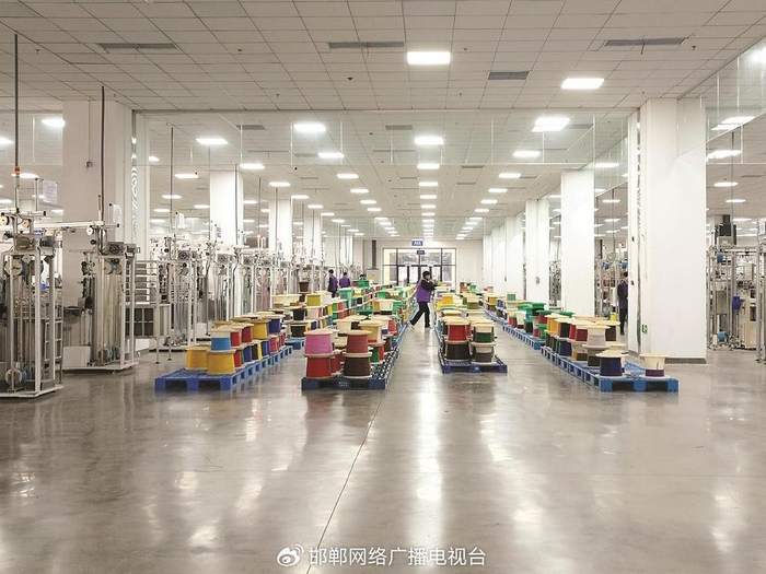 立讯精密工业（邯郸）有限公司新厂房内，工人正在新能源汽车线束生产线上忙碌。 贾深 摄