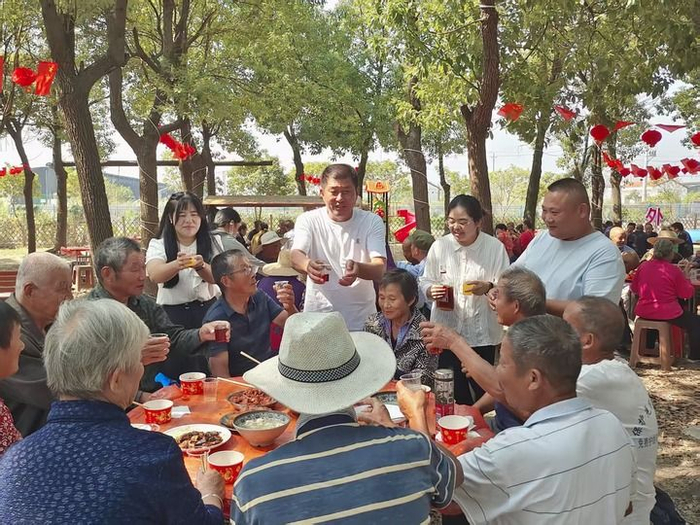 外岭村重阳节百叟宴上，吴劲松与村“两委”同事给老人送祝福。新华社发（外岭村供图）