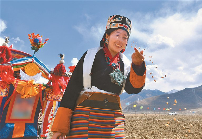 在拉萨市墨竹工卡县唐加乡春耕春播启动仪式上，当地妇女正在播种。记者   旦增兰泽 摄