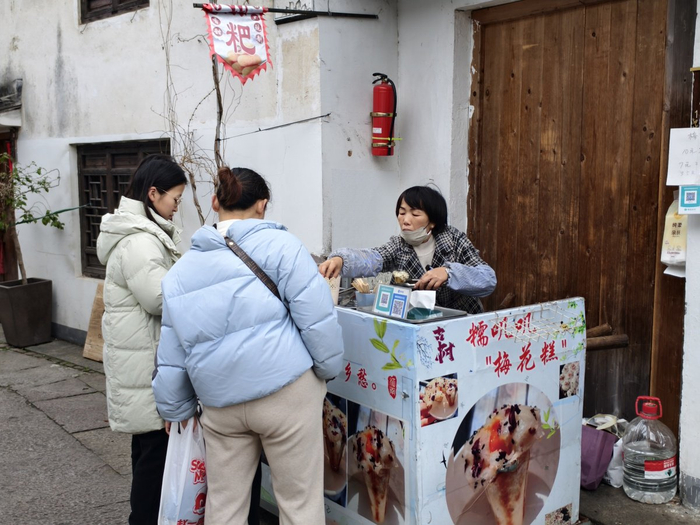 覃会兰在方家河头村的老街上卖梅花糕。本文图片除注明外均由周晓思摄