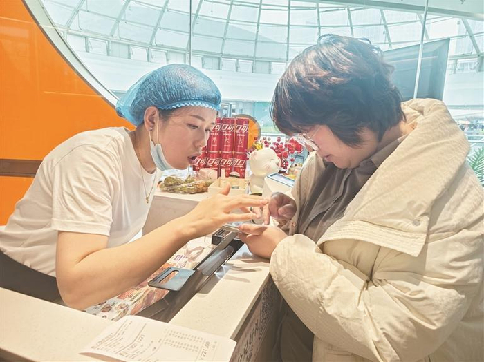 餐饮店工作人员为消费者答疑。