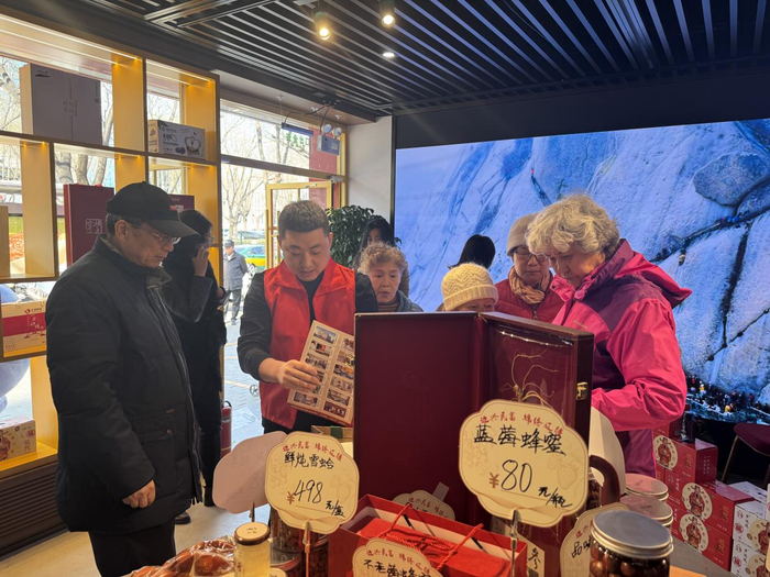   3月16日，国家民委民族地区乡村振兴成果展示馆内，展销员正向参观者介绍产品。新华网 吴京泽 摄
