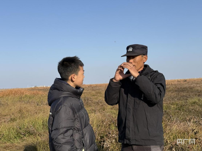 袁文斌正在给袁梓宸展示灰鹤叫声（央广网见习记者  尹博  摄）