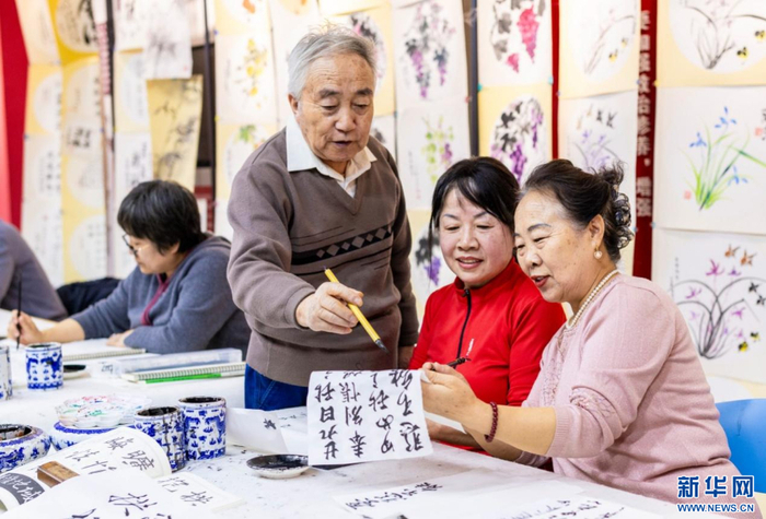   老年学员在呼和浩特市玉泉区老年大学书法课上交流书法技艺。新华网发（丁根厚 摄）