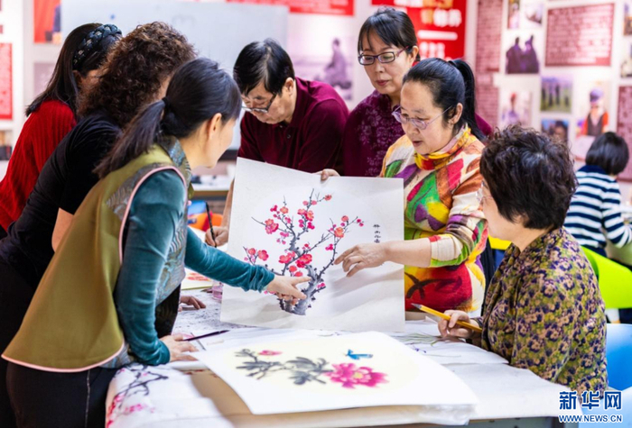   老年学员在呼和浩特市玉泉区老年大学绘画课上交流国画技艺。新华网发（丁根厚 摄）