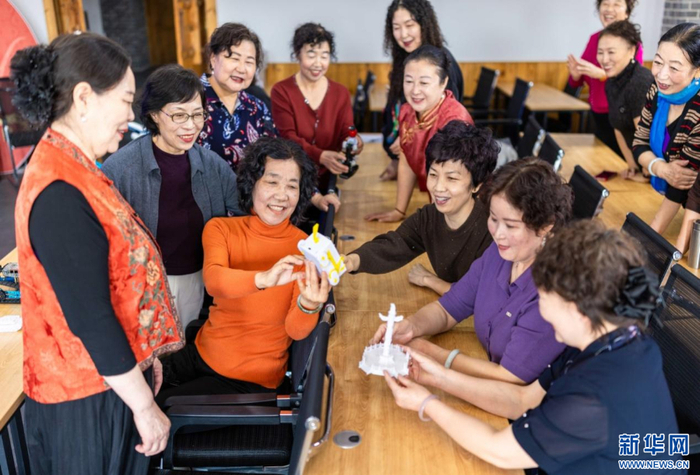   老年学员在呼和浩特市玉泉区老年大学智能应用课上观看3D打印模型。新华网发（丁根厚 摄）