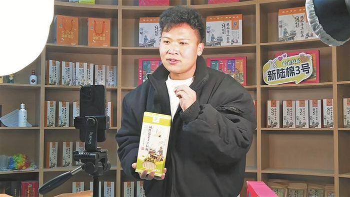     七师一二八团电商直播间内，杨云龙通过直播推介团场优质农副产品，拓宽销售渠道（摄于2月28日）。彭兴虎  摄