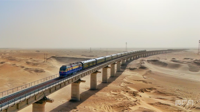 一列客运列车通过沙漠区段的特大桥，穿行于塔克拉玛干沙漠腹地的和若铁路  （央广网发  摆风亮  摄）