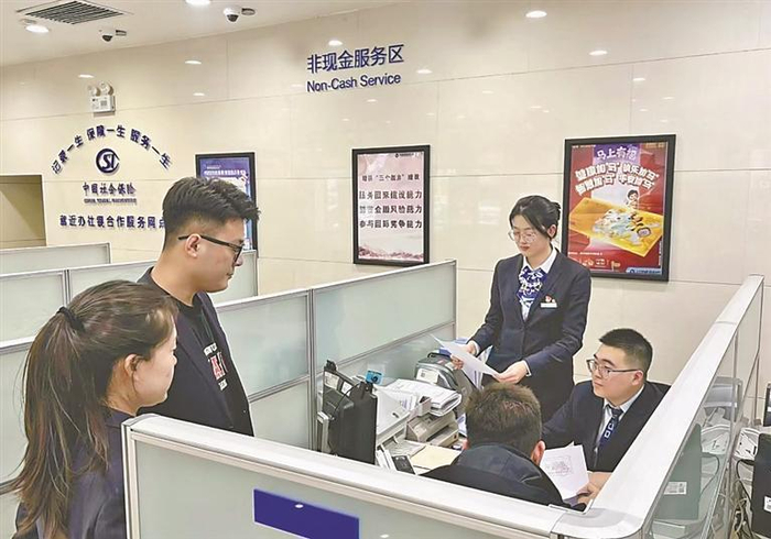     银行工作人员为企业办理贷款。本报记者 张翎摄