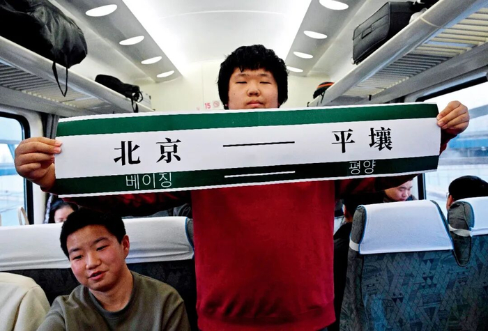 3月12日，北京开往平壤的K27次列车上，一名乘客手持写有“北京—平壤”的横幅。图/视觉中国