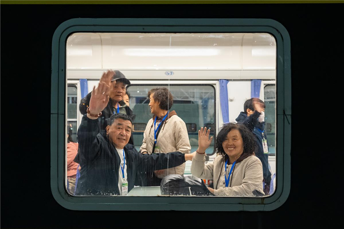 游客乘坐Y75次旅游专列启程，向窗外挥手告别。杨颐 摄