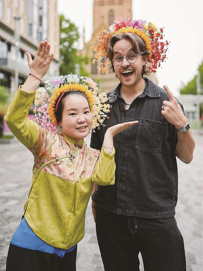 在澳大利亚墨尔本，黄丽泳与头戴簪花围的外国小伙合影。（受访者供图）