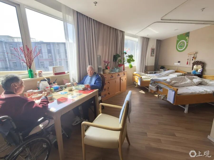 张老伯和老伴面对面吃着午餐。周楠 摄